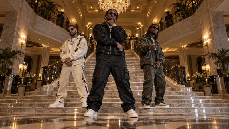Illustrated scene reference of three fictional rap performers standing on the marble staircase of a grand hotel lobby